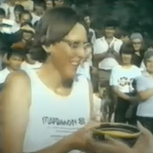 Eleanor Adams in a white Spartathlon 83 vest being handed a pottery bowl to drink from