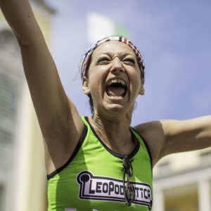 A female ultrarunner celebrates on crossing the line at the 100km Del Passatore