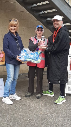British ultrarunner Gareth Pritchard accepting his award for winning the men's Crawley 24 Hour Track Race. Gareth is being presented with his prize by Rose George and Pam Storey.