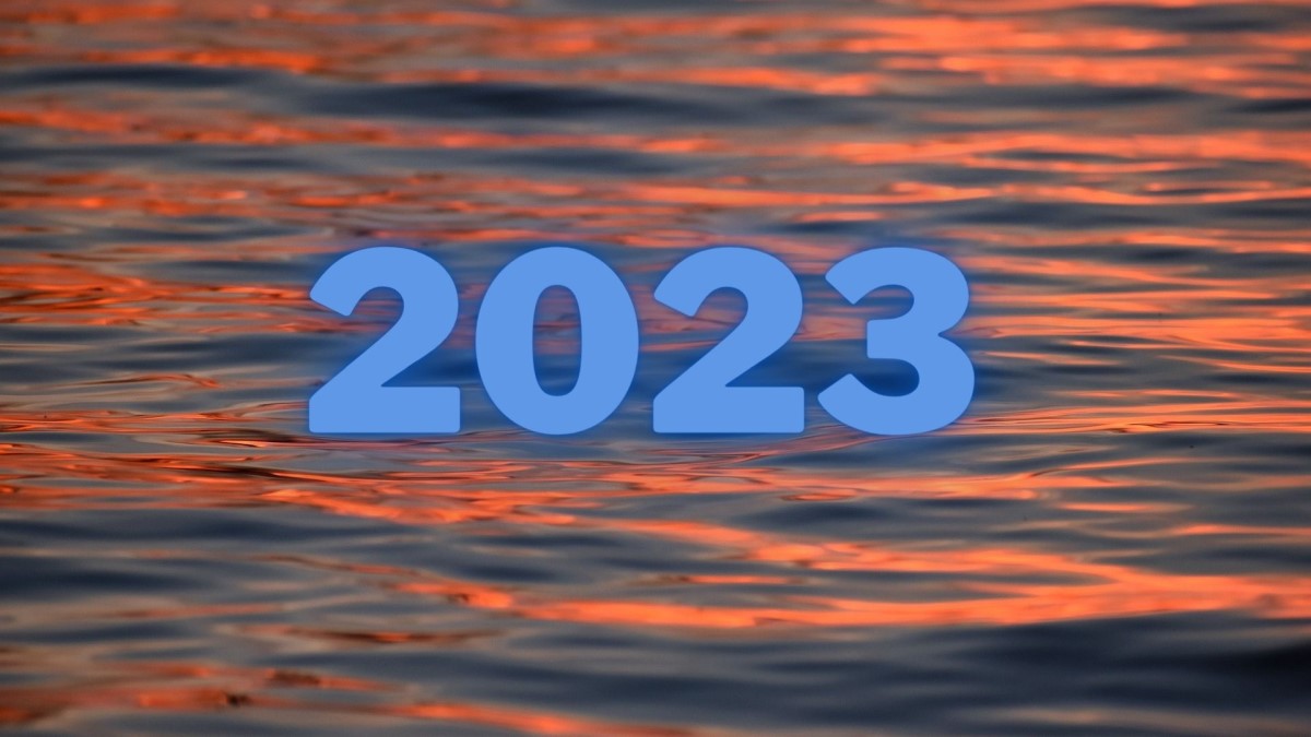 Waves lit by the setting sun with 2023 superimposed on the image.